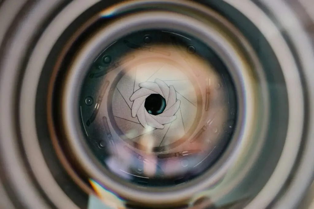 a cat looking through a hole in a wall